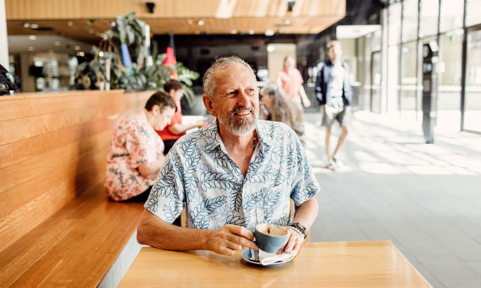 Man sitting in coffee shop, smiling