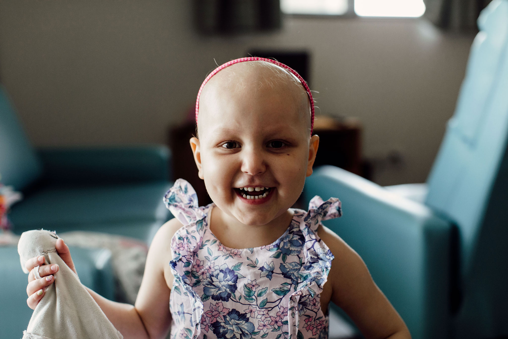 Young girl with blood cancer plays with her toys.