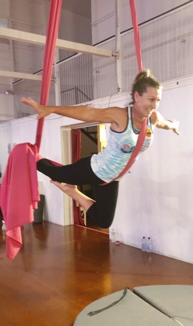 Samantha hanging from some aerial yoga ropes