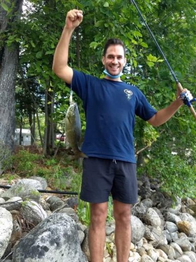 Matt Witkowski holding up a fish and fishing line