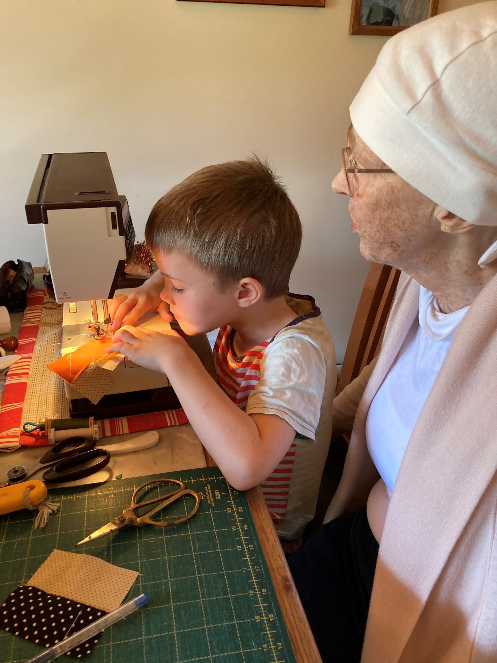 Shirley teaching her grandson, Darcy, to sew 