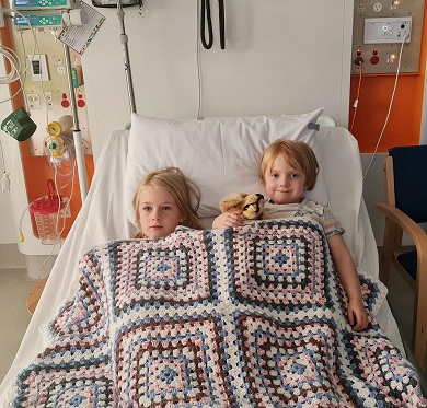 Emily in hospital with big sister, Jessica.