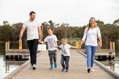 Hunter and his parents and brother walk along a pier