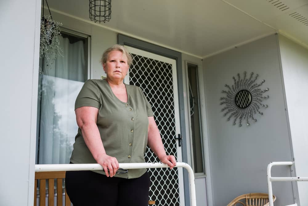 Katrina Richards stands on the porch of her home