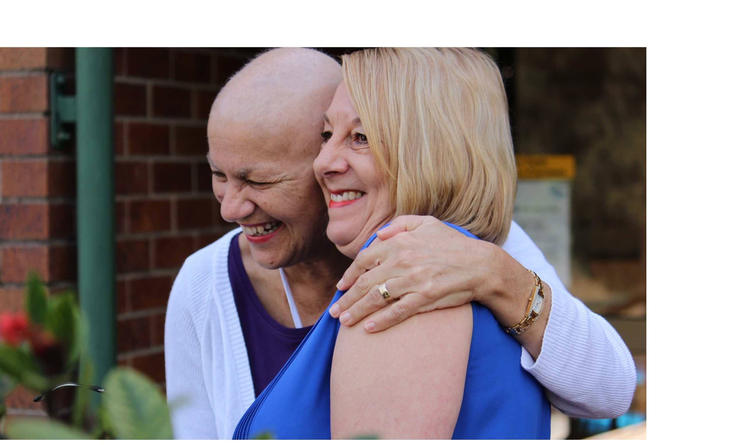 A smiling female patient hugs a Leukaemia Foundation support worker
