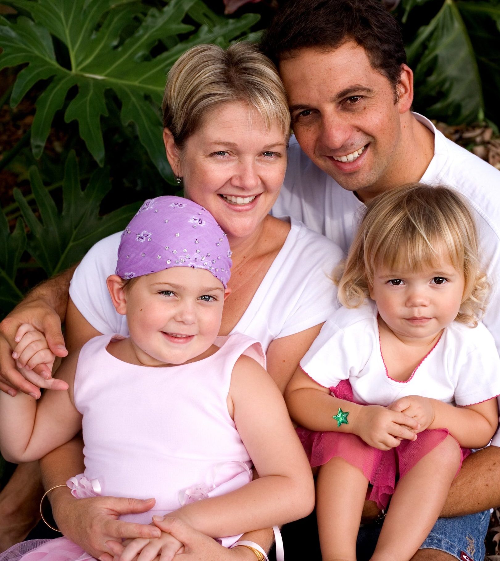 A smiling family - mum, dad, and two young daughters