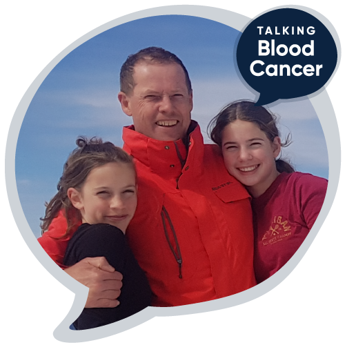 A man hugs his two daughters, all smiling at the camera, with the logo 'Talking blood cancer' on the image beside them